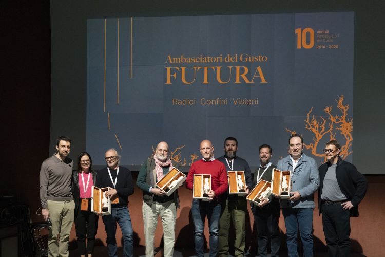 Sul palco, tra il direttore generale Gianluca De Cristofaro e il presidente Alessandro Gilmozzi, alcuni dei soci fondatori, dieci anni fa, degli Ambasciatori del Gusto, premiati per l'occasione: da sinistra la vicepresidente Mariella Caputo, Marco Sacco, il consigliere Paolo Marchi, Daniele Usai, Davide Del Duca, Giuseppe Carrus, Mimmo De Gregorio
