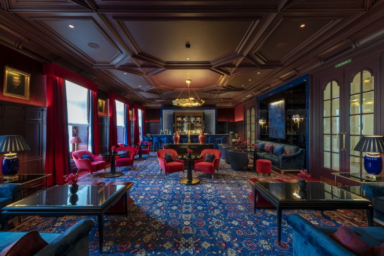La sera l'appuntamento è al Kronenhof Bar, che conserva la boiserie e il soffitto a cassettoni originali ed è dominato al centro da un lampadario dorato di Charles Paris chez Rubelli 
