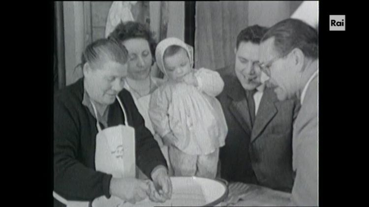 Gianni Brera e Mario Soldati, sulla destra, mentre assistono alla pratica secolare di mund&agrave; i ran&nbsp;("pulire le rane" ossia eviscerarle per renderle edibili), all'Antica Trattoria Ferrari di Borgo Ticino, Pavia, era il 1956, telecamere di Viaggio nella valle del Po, prima trasmissione televisiva dedicata (anche) alla cucina, questa puntata sarebbe andata in onda nel 1957
