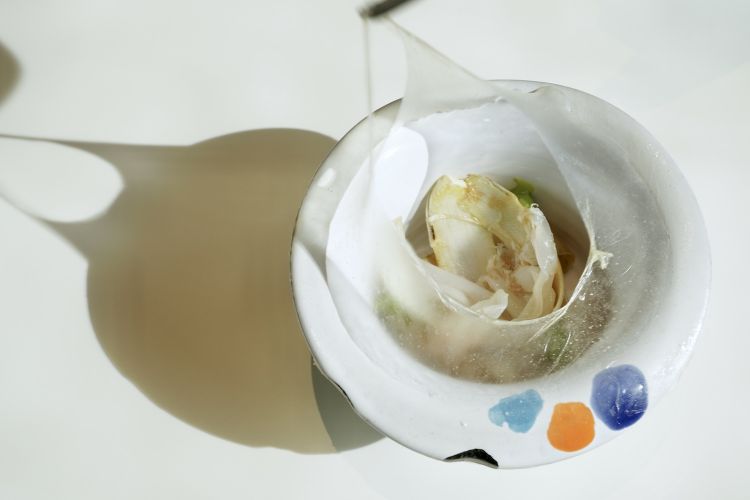 Una pellicola di amido, da bucare con la forchetta, nasconde un ottimo Guanciale, asparagi e crema di pistacchio