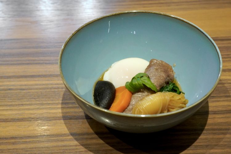 Sukiyaki: carne wagyū, carote, uovo cotto bt, funghi shiitake, spaghetti shirataki e spinaci. Gli shirataki si ottengono spingendo la pasta ottenuta dalla farina di konjac attraverso una griglia di lame che forma fili bianchi, come una cascata, da cui il nome shirataki, che significa letteralmente "cascata bianca"