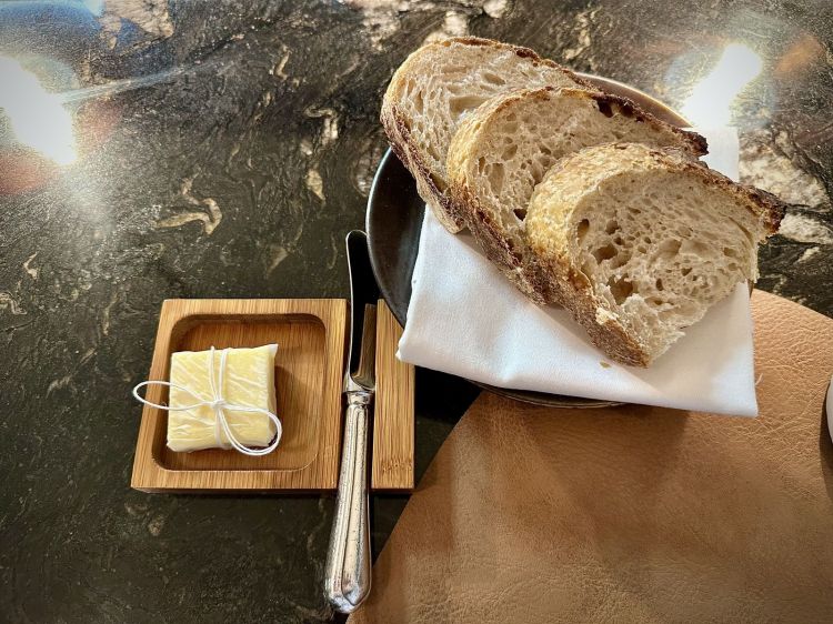 Pane realizzato con pasta madre (le farine vengono da un mulino che tratta grani antichi e locali, situato a 50 km da Parigi), burro fatto in casa a partire dalla panna non pastorizzata, affinato poi nel fieno 5 giorni
