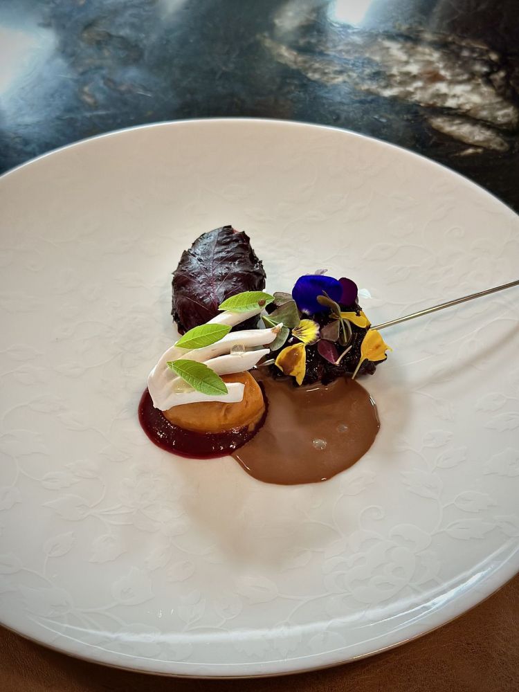 Gelatina montata alla mucillagine di cacao, curd alla prugna Lovita, prugna essiccata, zenzero fermentato, gelato al peperone crusco, salsa al cioccolato, Pastis e semi di finocchio. Aurora Storari spiega che la mucillagine di cacao è la polpa che sta attorno alla fava di cacao: molto acida, ricorda lo sciroppo di malto. Le piace usarla per rompere la credenza che il cioccolato sia qualcosa di molto torrefatto, morbido, vellutato o ricco: qui assume un gusto inedito, spiazzante. Questo dessert è qualcosa che va oltre alla pasticceria in sè, ma abbraccia tutta la cucina, dagli ingredienti "insoliti", ai sapori, alla costruzione. Il pensiero della cucina di Hémicycle si estende anche nei dessert, cosa non così comune, ma lodevole quando si manifesta
