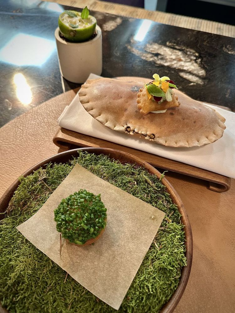 Il benvenuto: Frittella ripiena di haddock affumicato, mostarda di albicocche, erba cipollina; Raviolo croccante ripieno di granciporro, maionese alle erbe, kimchi di porro; Lime, melone e basilico
