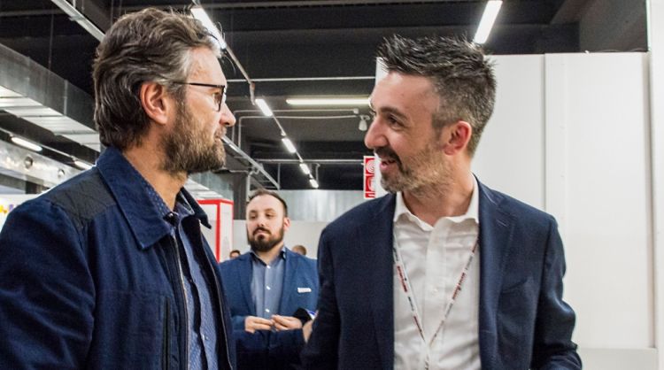 Andrea Balotelli, a destra, fotografato durante il Congresso 2019 di Identità Golose, mentre riceve la visita di Carlo Cracco allo stand Mepra
