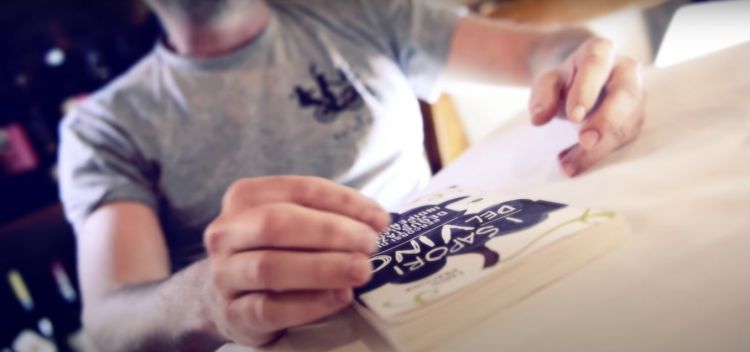 L'autore stringe il suo ultimo libro "I Sapori del Vino. Percorsi di degustazione per palati indipendenti" (Slow Food editore)