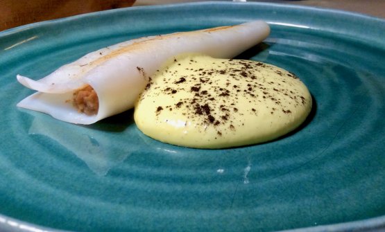 Calamaro ripieno con farcia di uvetta, pane nero raffermo, pistacchio e arancio, accompagnato da una crema olandese spolverata di pino bruciato
