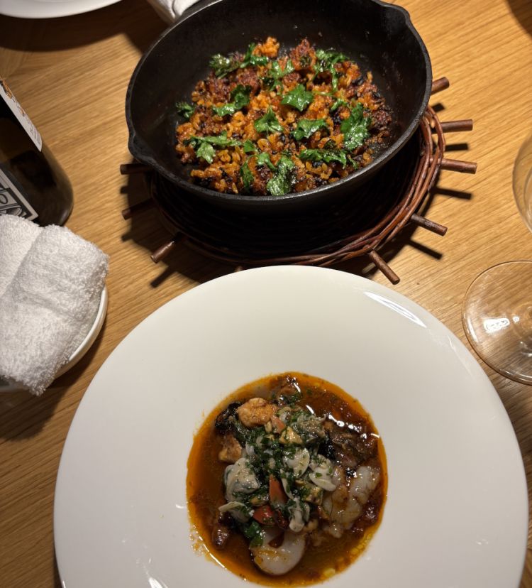 Brodetto di pesci, molluschi e crostacei cotto nel forno a legna servito con riso croccante e frutti di mare