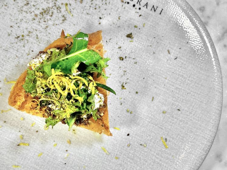 Contaminazione: trancio di pizza fritta con alla base paté di olive, misticanza, stracciata di bufala, za'atar e zest di limone. Lo za’atar - una miscela di spezie originaria del Levante - rimane un po’ sottotraccia