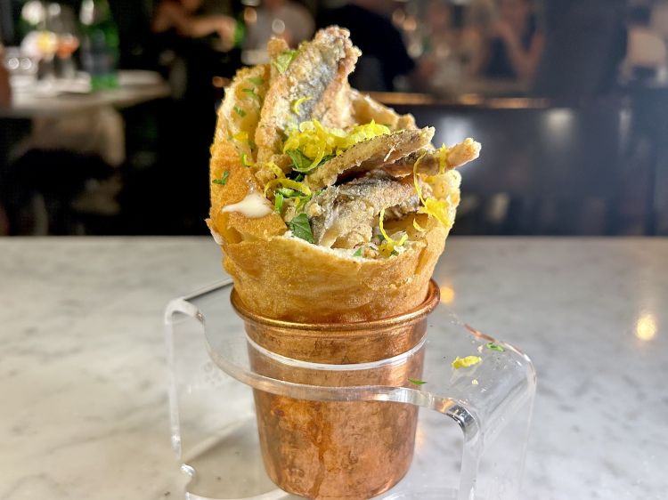 Cuoppo di alici: cono fritto con fonduta di grana padano 12 mesi, alici fritte, prezzemolo, pepe, zest di limone, all’interno del cono anche un geniale "cuore di limone" - come il fondo di cioccolato del cornetto gelato – che dà freschezza e pulisce