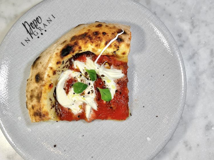 Vulcanica, in tre lavorazioni: in forno con paté di olive caiazzane, a metà cottura viene aggiunta la passata di pomodoro lungo dell’agro sarnese, alla fine - a freddo - treccia di mozzarella di bufala sfilacciata a mano, cappero disidratato e origano fresco. Dritta, pulita, è la Campania de gusto, una classica senza essere classica, «ho voluto far capire come utilizzare la treccia di bufala su una pizza senza perdere nulla del suo sapore. Non va tagliata col coltello, perdendone il latte, né sgocciolata, basta sfilacciarla con le mani seguendo le sue nervature»