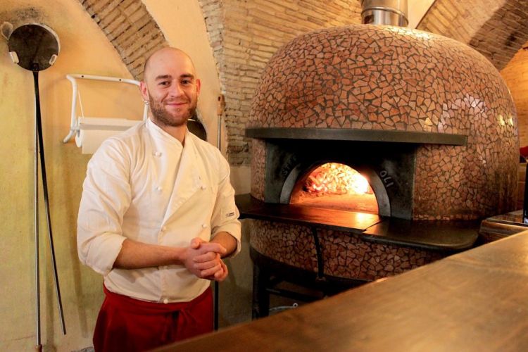 Sabino Stingone in front of the oven in his pizze