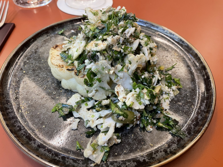 Cavolfiore alla brace, burro di datteri, insalata di erbe capperi e limone salato