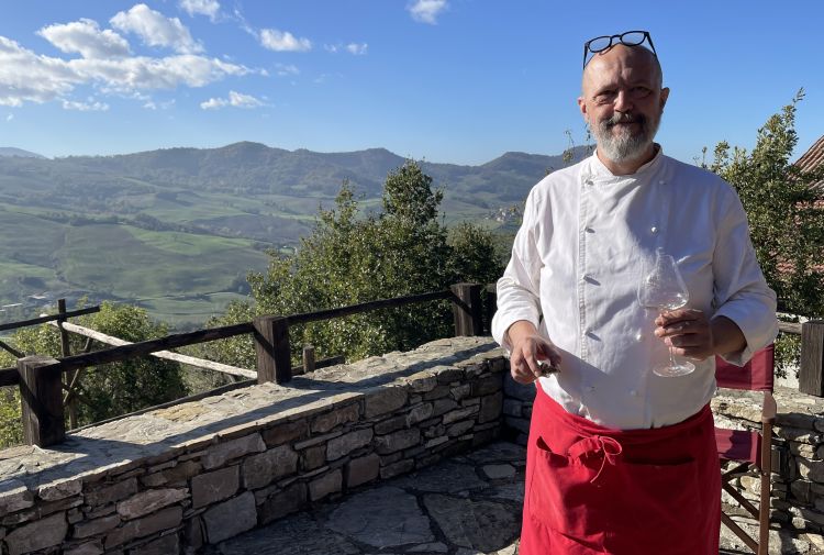 Michele Milani in veste di cuoco, con alle spalle