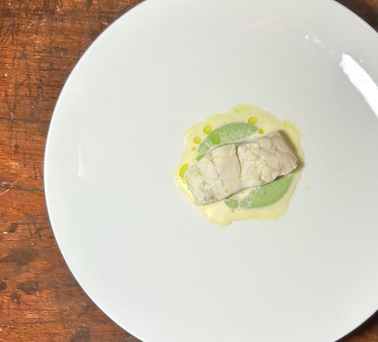 Spigola in court bouillon, crema di finocchio e finocchietto selvatico, crema di mandorle. Un piatto comfort food con rimandi francesi, tecnicamente molto ben realizzato, con il finocchietto a fare da controcanto