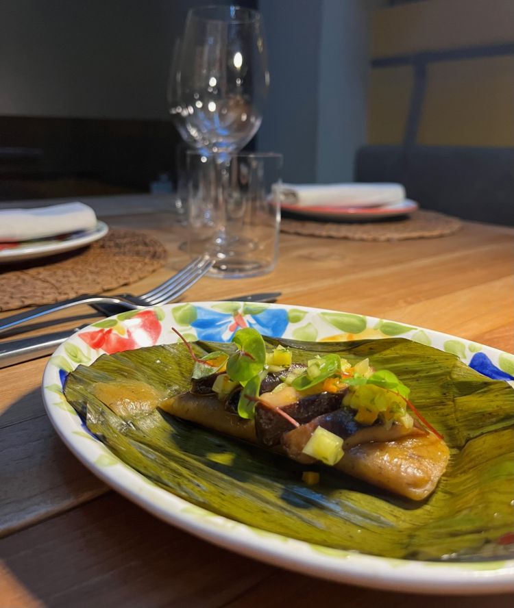 Tamales visto dallo chef Clavijo su foglia aperta per mostrarne il contenuto con shitake y aji di mango
