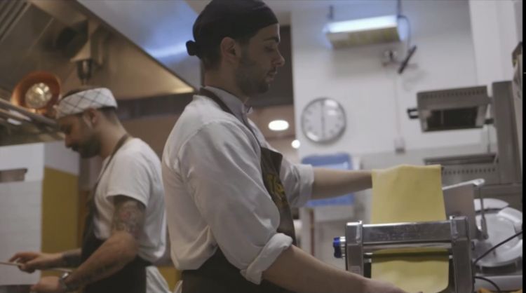 Una delle scene del video di apertura: Diego Rossi in cucina mentre lavora con la sua squadra
