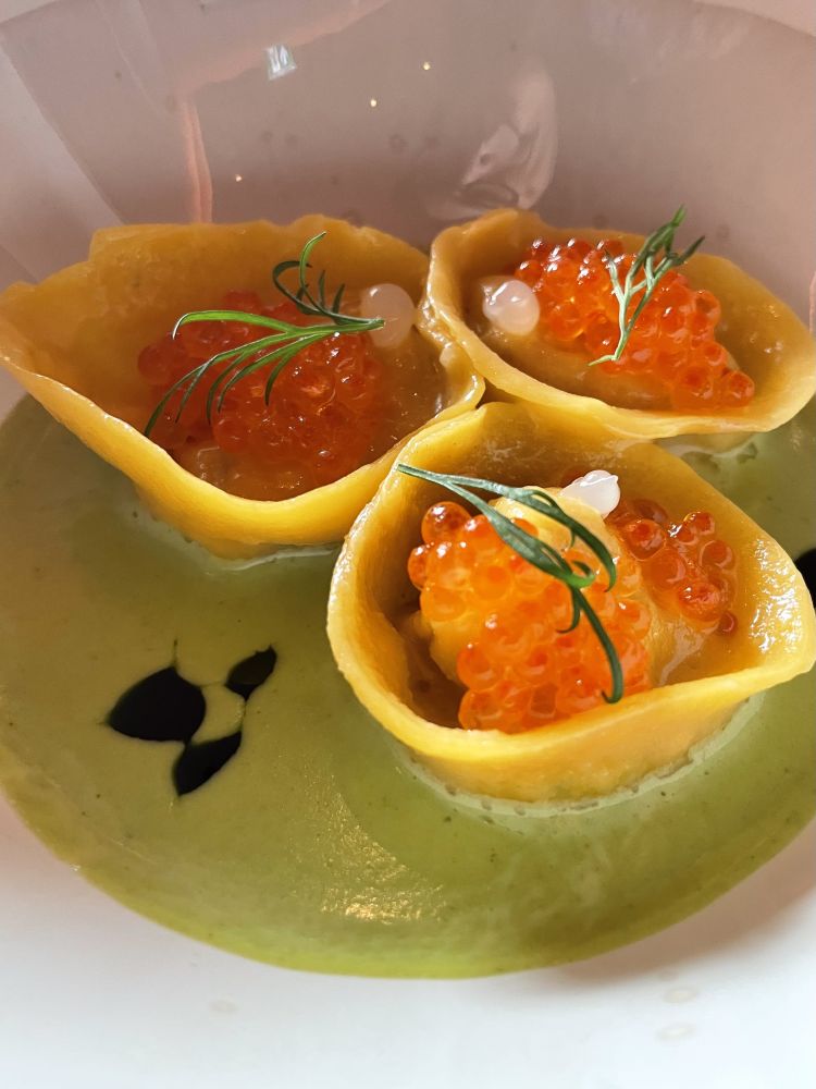 Ravioli di trota: uova di trota, salsa all'aneto. La pasta &egrave; porosa; il ripieno resta umido e carnoso tra i veli dorati, mentre il tocco dell'aneto accompagna il palato fino al boccone successivo, affievolendo la salinit&agrave; delicata&nbsp;delle uova di trota
