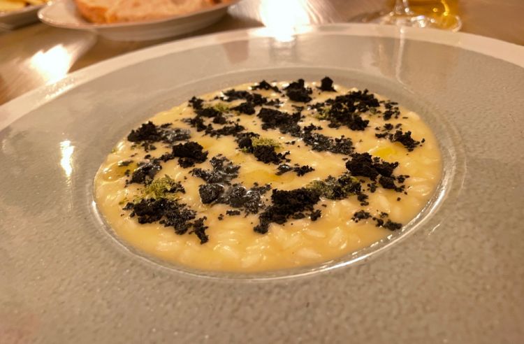 Risotto mantecato all'olio extravergine, polvere di olive affumicate e origano
