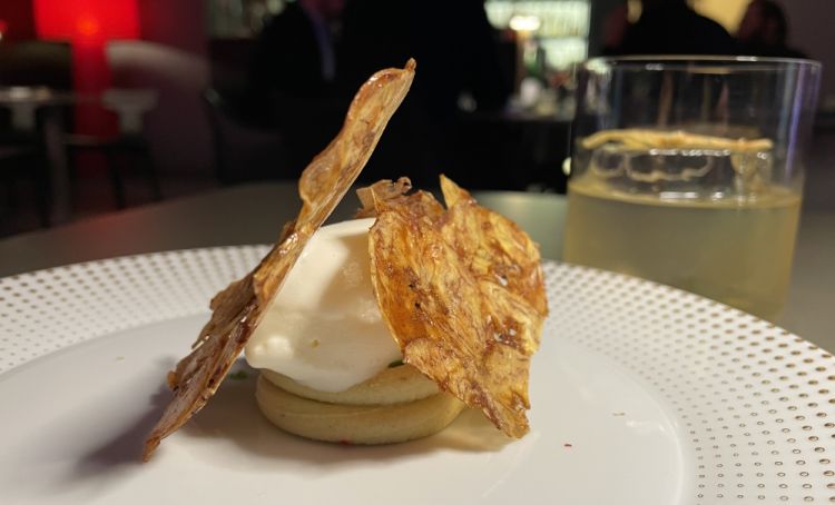 Platano, mirtilli e kefir
«Il piatto è il frutto del nostro lavoro sul platano, proposto in due stadi di maturazione: quello ancora verde, con molti carboidrati all'interno, lo tagliamo molto sottile per ottenere una cialda, spennellandolo poi con dello zucchero, per ottenere una parte croccante. Il platano molto maturo, quando diventa completamente nero, lo mettiamo invece nel forno alla brace, lo facciamo arrostire e poi prendiamo la polpa per ottenere, con del cioccolato bianco, una specie di namelaka. Infin usiamo aromi come pepe rosa, rucola e lime, concludendo con un gelato di kefir per dare freschezza»