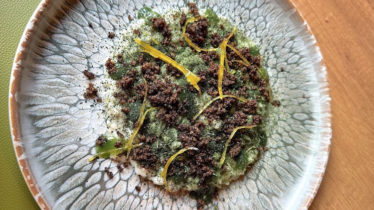 Risotto al blu di Campertogno, ortica, limone e caffè
Il riso è cotto al dente e mantecato con del blu di Campertogno. Completano il piatto la polvere di ortica essiccata, scorze di limone candito e polvere di caffè, quest'ultimo un po’ dominante rispetto agli altri ingredienti.
In abbinamento ci viene servito un calice di rosè delle Colline Novaresi, EROS Paride Chiovini 2022