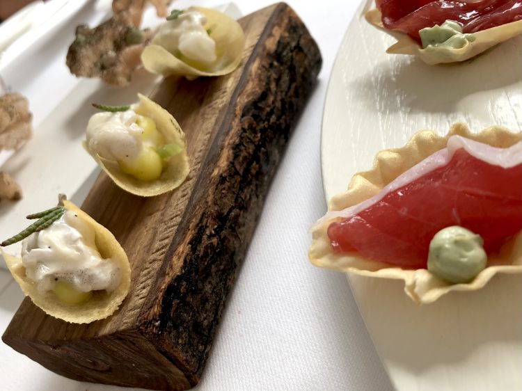 Il benevenuto a tavola di Gianfranco Pascucci: tacos di cococias di baccalà con patate, come una burrata di mare; cialde sapido-amare alle alghe, una passeggiata nell'oasi di Fiumicino; stella marina tonnata