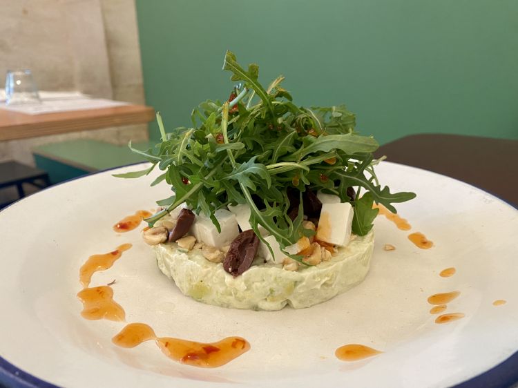 Tartare di avocado, primosale e mele con patate, formaggio cremoso, olive, maionese, salsa chili, nocciole e rucola&nbsp;da Frulez
