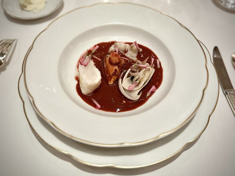 Il genio creativo di Giuliano Sperandio passa da piatti creati à-la-minute, cioè durante il servizio, a seconda del dialogo con gli ospiti. Un esempio: la Zuppa di pesce con San Pietro, cozze, seppioline, mandorle, salsa al pepe verde e rapa rossa, perlage di limone. Elegantissima, colorata e coinvolgente già dall'aroma: sembrava esserci del coriandolo, ma era l’effetto aromatico del pepe, che in bocca regalava un altro gusto
