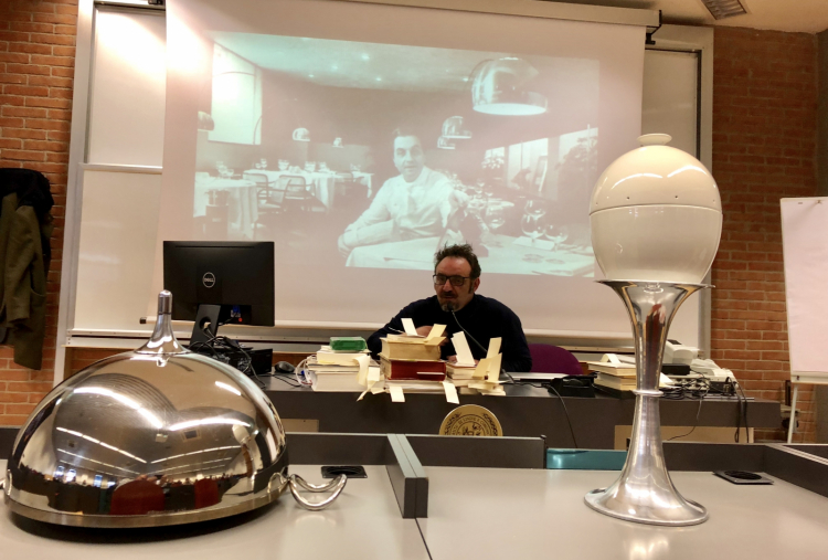 Lopriore tra libri e utensili della sua trattoria. Alle spalle, il suo maestro Gualtiero Marchesi