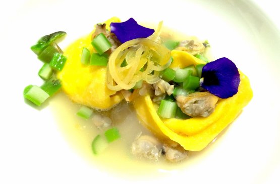 Raviolo ripieno di tomme (formaggio) in guazzetto di vongole con limone candito e asparagi
