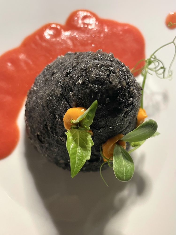 Arancina al nero ripiena di tartare di baccalà
