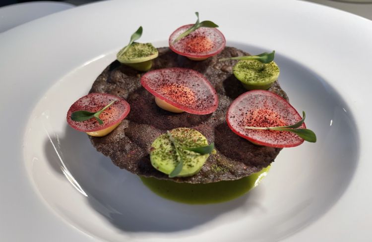 Un piatto che è giustamente diventato un simbolo della cucina di Karime Lopez alla Gucci Osteria, e di cui si sente nostalgia appena si finisce di mangiarlo, Tostada di mais viola con palamita dell’Adriatico: «Questo piatto nasce inizialmente da uno stimolo di Massimo Bottura, che voleva che proponessi un'interpretazione di un classico messicano che si chiama Huevos rancheros. Ma per me quello è un piatto da colazione, non riuscivo a trovare una chiave che mi soddisfacesse. Poi ho avuto l'idea per questa tostada: utilizzo dei fantastici ingredienti italiani, come la palamita, i limoni di Siracusa, il mais viola che abbiamo trovato a Perugia. Quindi è una tostada italiana, fatta con una tecnica messicana»
