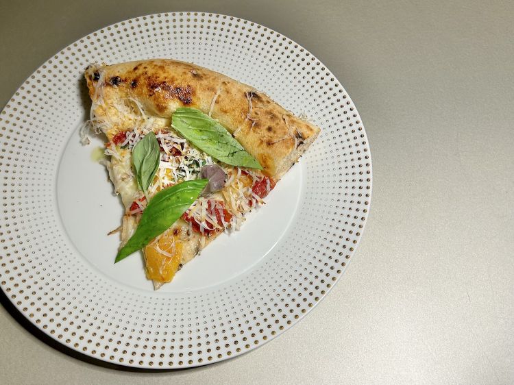 Pizza SuperProvolaePepe (in cottura provola dei monti Latteria Sorrentina, pacchatelle gialle Casa Marrazzo, sfilacci di pomodoro arrosto e basilico; in uscita ricottina affumicata, basilico viola e pepe macinato fresco)