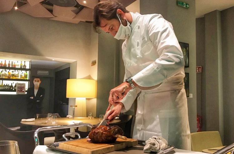 Luigi Taglienti impegnato a porzionare in sala il coscio di agnello per uno dei piatti del suo menu
