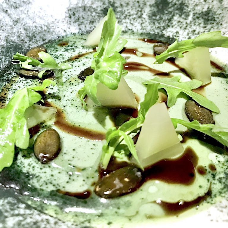 Un dessert a fuoco, estremamente contemporaneo, è questa Panna cotta di alga spirulina, semi di zucca, cetrioli, caramello di capperi. Solo complimenti