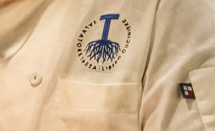 Il logo disegnato da Bob Noto per Salvatore Tassa, cucito sulla sua giacca insieme alla definizione: "libero cuciniere"
