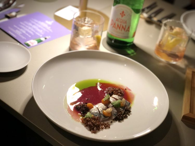 Selva Alta/Tiradito Andino di Alexander Robles
Tiradito di sgombro salmistrato con miso e lime servito con tarwi, quinoa nera e bianca, camote e leche all'ayrampo, seme del cactus peruviano

La carne dello sgombro dolce, compatta, viene vivacizzata dalla spinta acido-piccante del dressing (leche de tigre) che assume questa colorazione magenta, sgargiante, opera dell'ayrampo, il seme del cactus, solitamente utilizzato per tingere tessuti nella cultura peruviana; l'impatto energico del boccone viene mitigato dal tarwi, un lupino andino che ricalca le note di una mandorla amara. Infine, nel piatto, un doppio gioco di consistenze con la quinoa, preparata sia alla maniera classica, che soffiata come un pop corn

In abbinamento il drink di Andrea Fornero a base di Mezcal Vida del Maguey, Amaro salato Gabelle, estratto di pomodoro, fermentato di cavolo viola all'alloro, scorza di limone
