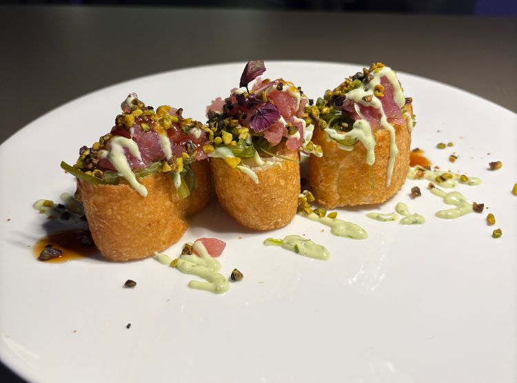Uramaki fusion pizza - Manuel Maiorano
Roll di focaccia al vapore e tostata in forno, alga wakame marinata con soia e sesamo, tartare di tonno, maionese, erba cipollina, granella di pistacchio. L'evoluzione della pizza che dialoga con il Giappone: una base che rimane croccante grazie all'emulsione di olio extravergine nella cottura al vapore, con topping che raccontano l'Italia attraverso tecniche orientali