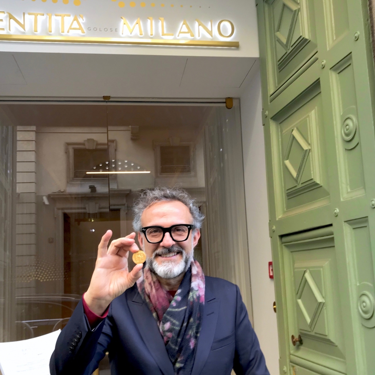 Massimo Bottura mostra la medaglia d'oro ricevuta dal Comune di Milano davanti all'entrata di Identità Golose Milano
