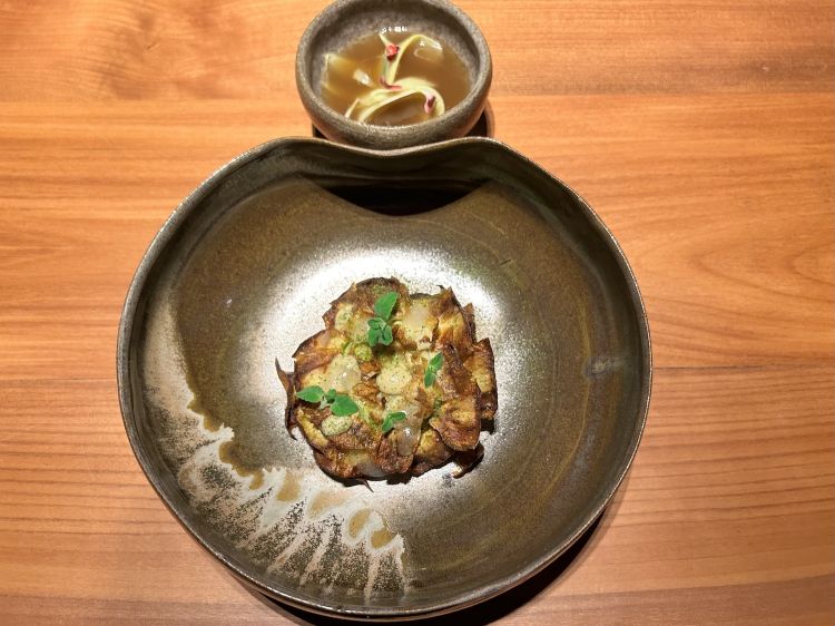 Il carciofo, omaggio a Roma. L'ortaggio è cotto alla barigoule, coperto con crema di carciofo ridotta, foglioline di menta e polvere di pino mugo. I gambi al vapore con olio, sale e limone e bagnati con brodo ridotto di carciofo con aggiunta di limoncello
