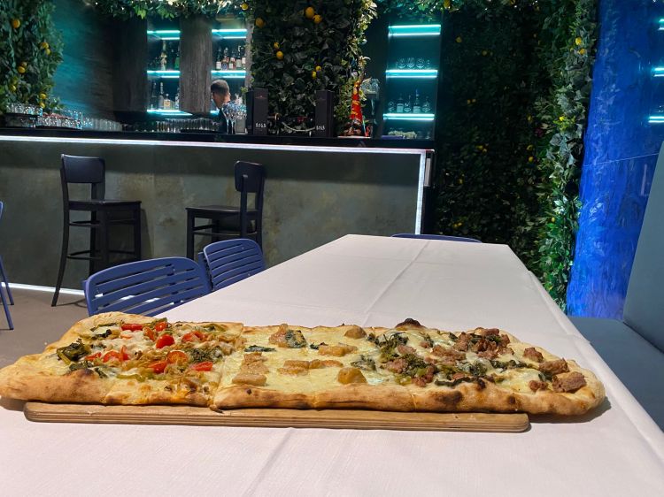La pizza è a metà tra la napoletana e la romana. Cornicione con finale croccante, topping a base di materie prime per lo più campane
