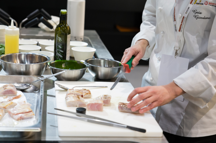 La preparazione del piatto "Mare e Champagne": il taglio della ricciola