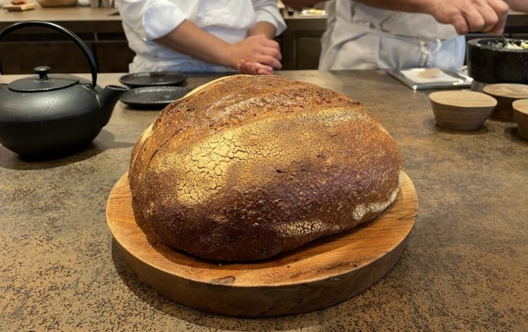 Il pranzo si apre sempre con il Pane, servito con olio extravergine catalano, e con un Brodo di anguilla affumicata, pinoli e dragoncello
