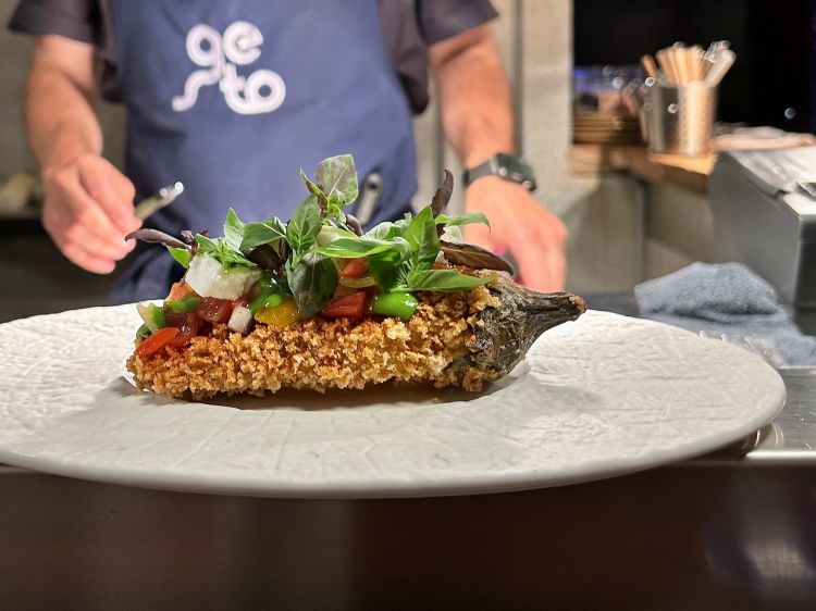 Parmigiana d’estate: melanzana al bbq e pressata, impanata in crosta di panko e fritta, poi condita con polvere di pomodoro, variazione di basilico, pomodoro e mozzarella di bufala