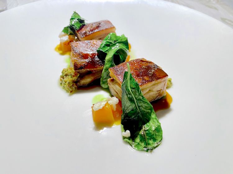 Maialino arrosto accompagnato da una salsa gribiche, albicocche grigliate, chutney di alblicocche, cavolo nero e popcorn di cotenna soffiata