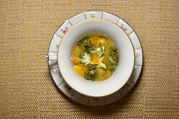 Partono gli snack di benvenuto: Paninetto al vapore, farcito con lattughino grigliato, crema di yogurt e salsa muhammara, ossia salsa orientale a base di peperoni e arachidi (un po' scarico), poi Cannolo di melanzana al saor, ossia un roll di melanzana che riprende la preparazione veneziana del saor, con melanzana, cipolla e uvetta (buono) e Cozza scottata, completata da un elemento croccante che ricrea la forma del guscio, ovvero una chips di riso al nero di seppia (drittissimo nella sua essenzialità). Il primo antipasto è Laguna, nella foto. Prende ispirazione da un quadro di Paolo Benvenuto, in sala. Alla base c’è un chawanmushi, il flan morbido giapponese, preparato con acqua di ostriche e uova. Viene completato con caviale, ricci di mare, granchio blu, salicornia e finocchietto marino: tutti elementi pensati per restituire una sensazione di laguna. È un salmastro raffinato e cremoso, dove non c'è masticazione (e pure poca texture, se ci fa eccezione per le uova di pesce che scoppiano tra lingua e palato), ma ogni singolo elemento va in un'unica direzione di gusto, in modo elegante