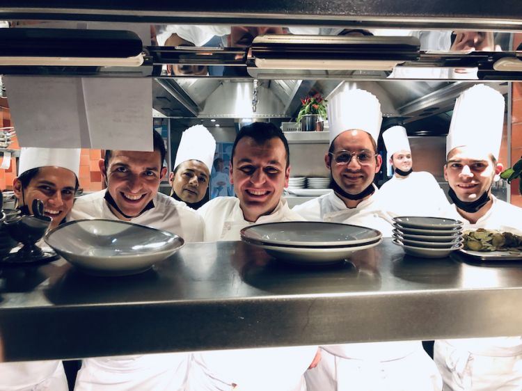 By the pass at Langosteria Paris, in the middle without the hat, chef Michele Biassoni. Then Mirko Vinci, executive sous chef, he's the second from the left, two people on their side, left Luigi Nonatelli and right Marco Piccoli. The young man to the right of the chef is Alessandro Stella. Unfortunately, when the photo was taken sous chef Stefano Lanfredi was not there