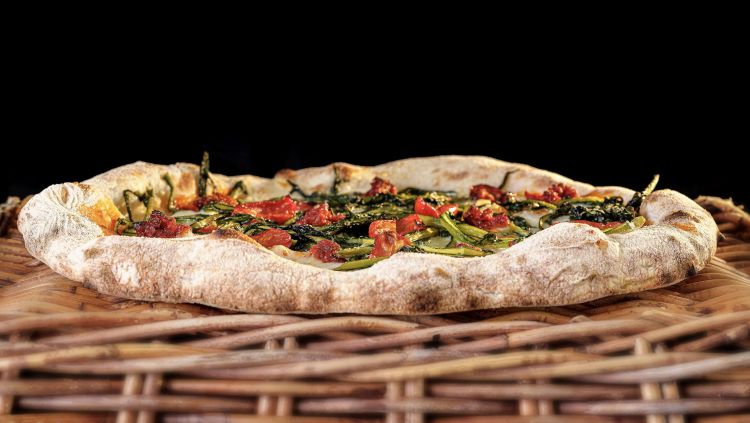 Fuoco di vulcano, pizza tonda con cicoria saltata, fiordilatte, nduja di spilinga, datterino semi dry, parmigiano reggiano