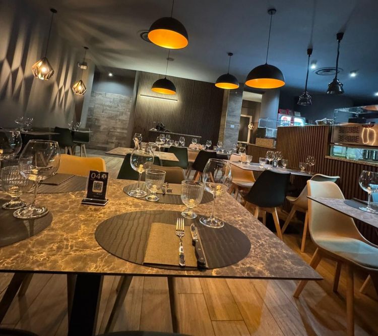 L'interno della pizzeria, ristrutturata con un design elegante e forno e banco di lavoro a vista