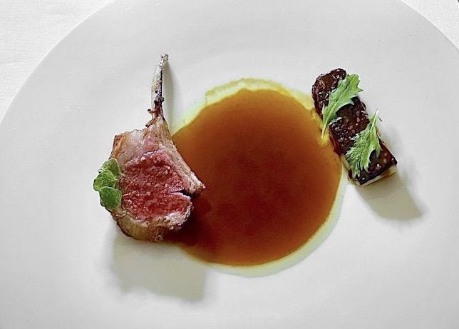 Agnello al bbq, servito con la sua tartare, nepitella e altre erbe, melanzana in salsa satay e miele ibleo: in accompagnamento, un grande vino al calice (Nicolò Grippaldi, Nero D'Avola e Nerello Mascalese Dei Pinti 2018), a testimonianza della vasta scelta dalla cantina
